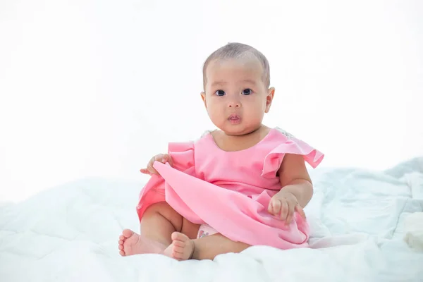 Baby Sitzt Auf Einem Weißen Bett — Stockfoto