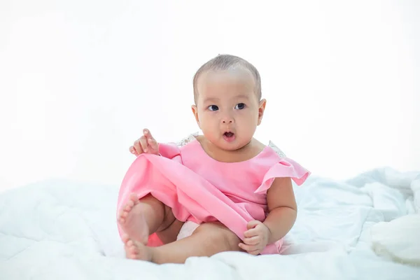 Baby Sitzt Auf Einem Weißen Bett — Stockfoto