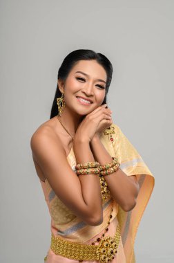 Taylandlı güzel bir kadın Tayland elbisesi ve mutlu bir gülümseme giyiyor..