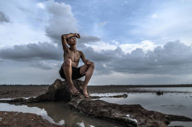 Adam ağacın dibine oturdu, elini alnına koydu ve suyla çevrili..