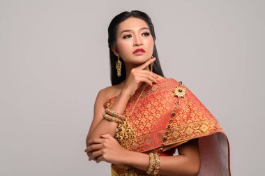 Taylandlı güzel bir kadın. Tayland elbisesi giyip en tepeye bakıyor.