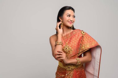 Taylandlı güzel bir kadın Tayland elbisesi ve mutlu bir gülümseme giyiyor..