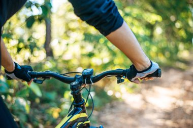 Dağ bisikletçileri bisiklet kolunu kavrayıp eldivenlere odaklanırlar.