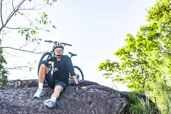 Athletes sitting on the mountain with bicycle