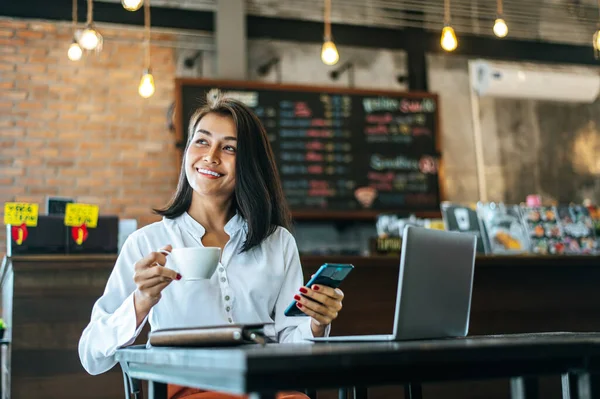 Kvinna Sitter Gärna Arbetar Med Smartphone Ett Kafé Och Anteckningsbok — Stockfoto