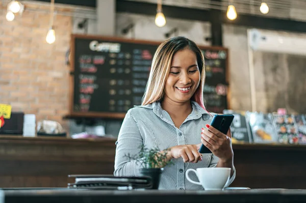 Kobieta Siedzi Szczęśliwa Pracując Smartfonem Kawiarni — Zdjęcie stockowe