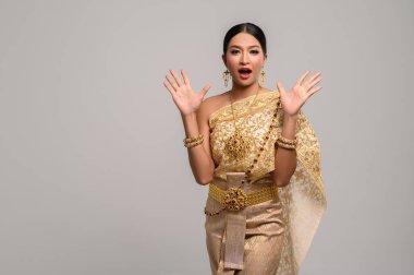 Kadınlar Tayland giysileri giyer ve ellerini iki taraftan da açarlar..