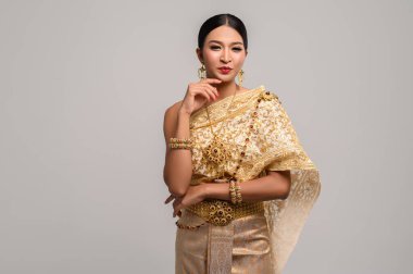 Tayland kıyafeti giyen ve çenesine dokunan kadınlar.