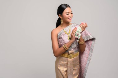 Tayland giysileri ve çiçek çelenkleri giyen kadınlar..