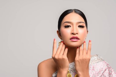 Tayland kıyafeti giyen ve ellerine dokunan kadınlar.