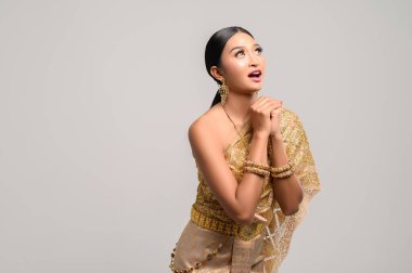 Taylandlı güzel kadınlar Tayland elbisesi giyer ve üstlerine bakarlar.