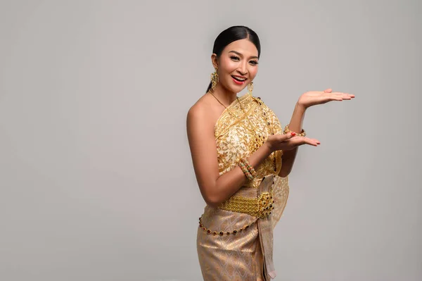 Beautiful Thai women wear Thai clothes and open his hand to the left