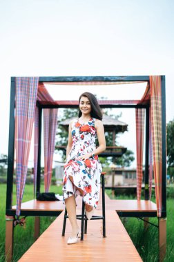 Kadın mutlu. Tahta köprüye otur.