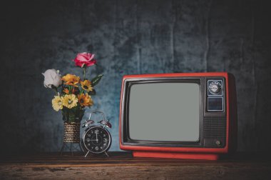 Eski retro TV, saatli ve çiçekli vazolarlı hayattır..