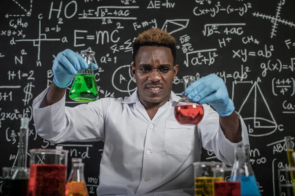 Scientists hold beakers with green and red chemicals and stressed faces.
