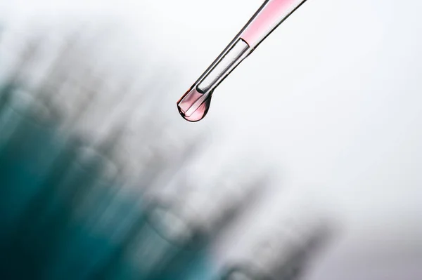 ピンクの化学物質をビーカーに落とす — ストック写真