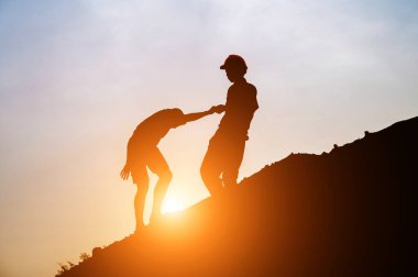Turistler gün doğumunda el sıkışmak için tepeye çıkarlar. Erkek gezgin, tepenin zirvesine tırmanan erkek yolcunun elini sıkar.