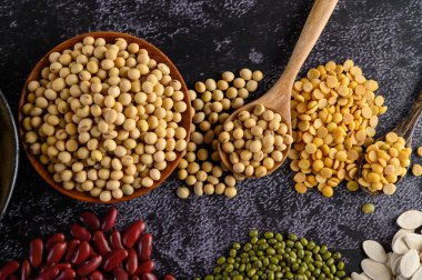 Legumes, ve siyah çimento zemininde fasulye çeşitleri. Üst görünüm.