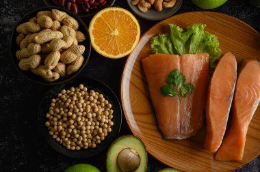 Legumes, meyve ve somon parçaları ahşap bir tabakta.