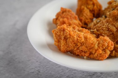 Beyaz bir tabağa biber tohumu serpiştirilmiş kızarmış tavuk, seçici odak noktası..