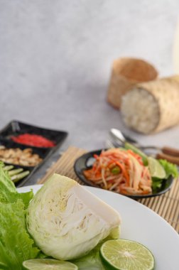 Lahana yeşili, limon, fasulye ve beyaz tabakta salata..