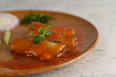 Seçici odak noktası domates soslu sardalya. Üstüne nane ve yemek malzemesi ahşap tepside düzenlenmişti. Kopya alanı.