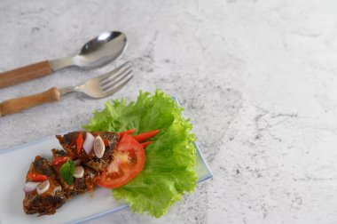 Baharatlı sardalya ve baharatlı aperatiflerle karıştırılmış beyaz tepsi, kaşık ve çatal neredeyse yerleştirilmiş, boşluğu kopyala