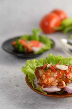 İştah açıcı baharatlı konserve sardalya salatası ve ahşap kasede baharatlı sos.