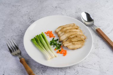 Buğulanmış tavuk göğsü ve taze soğan ve doğranmış havuç. Seçici odak.