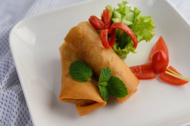 Beyaz tabakta yumurtalı börek ya da kızarmış Çin böreği. Seçici odak.