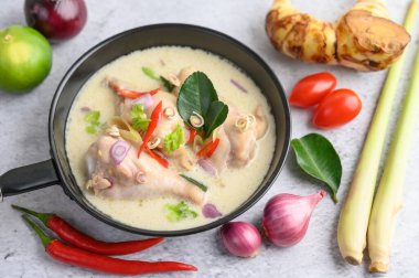 Tom Kha Kai tavada kaffir limon yaprağı, limon otu, kırmızı soğan, galangal ve biber ile kızarıyor..