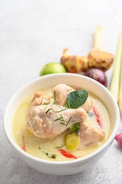 Tom Kha Kai kaffir limon yapraklı, limon otlu, kırmızı soğanlı, galangal ve biberli bir kasede.