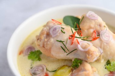 Tom Kha Kai kaffir limon yapraklı, limon otlu, kırmızı soğanlı, galangal ve biberli bir kasede.