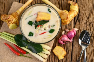 Tom Kha Kai kaffir limon yaprağı, limon otu, kırmızı soğan, galangal ve biberli bir kasede..