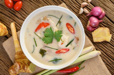 Tom Kha Kai kaffir limon yaprağı, limon otu, kırmızı soğan, galangal ve biberli bir kasede..