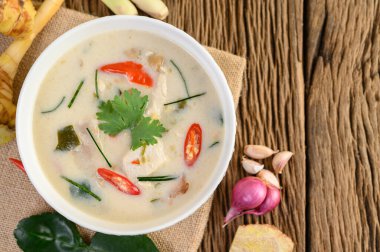 Tom Kha Kai kaffir limon yaprağı, limon otu, kırmızı soğan, galangal ve biberli bir kasede..