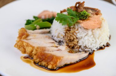  Sosla kaplı beyaz tabakta çıtır domuz eti. Seçici odak