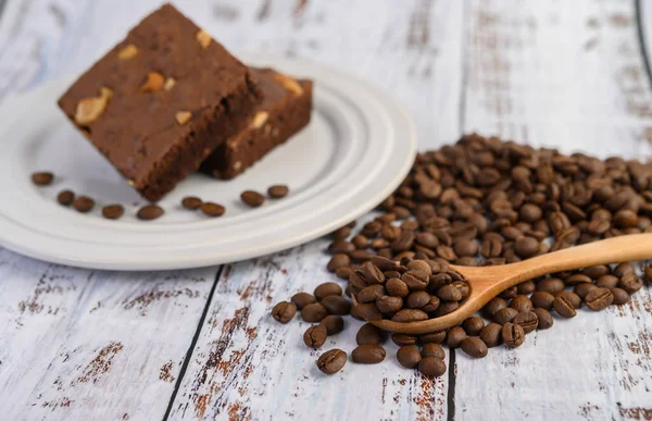 Chocolate Brownies White Plate Coffee Beans Wooden Spoon Selective Focus — Stock Photo, Image