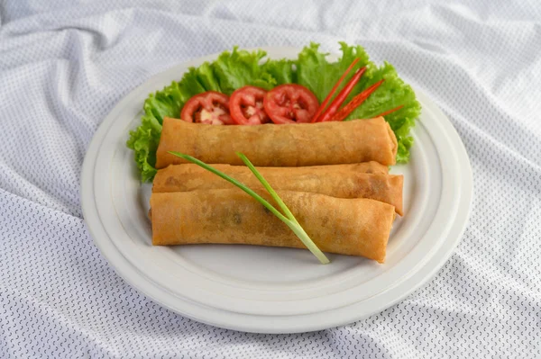 Egg roll or Fried Spring Rolls on the white plate Thai food. Selective focus.