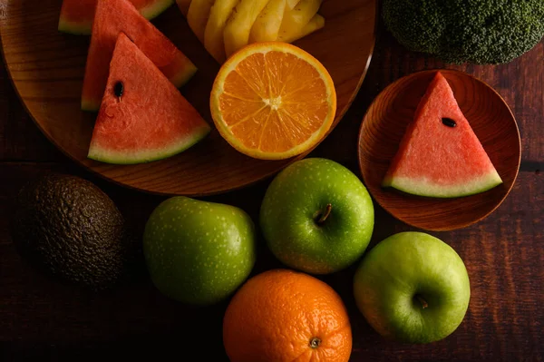 Meloun Ananas Pomeranče Nakrájené Kousky Avokádem Brokolicí Jablky Dřevěný Stůl — Stock fotografie