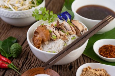 Yanında meze ve Tayland yemeği olan bir kasede tavuk eriştesi. Seçici odak