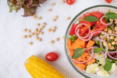 Beyaz bir zeminde cam bir fincanda meyve ve sebze salatası. Seçici Foucs