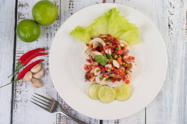 Baharatlı limonata, biber, havuç, nane şekeri, taze soğan ve beyaz ahşap bir tabakta sarımsak..