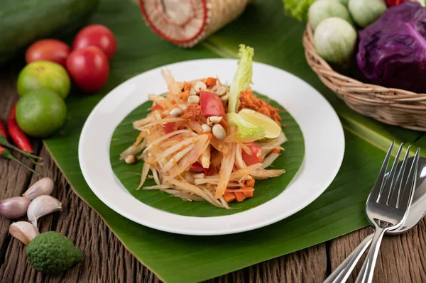 Ensalada Papaya Tailandesa Plato Blanco Sobre Hojas Plátano Con Lima —  Fotos de Stock