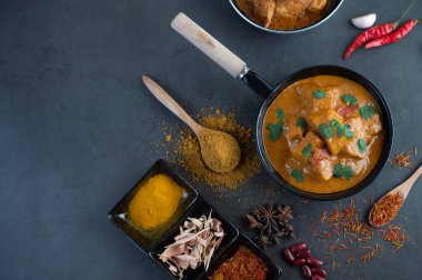 Massaman curry in a frying pan with spices on the cement floor. Selective focus clipart