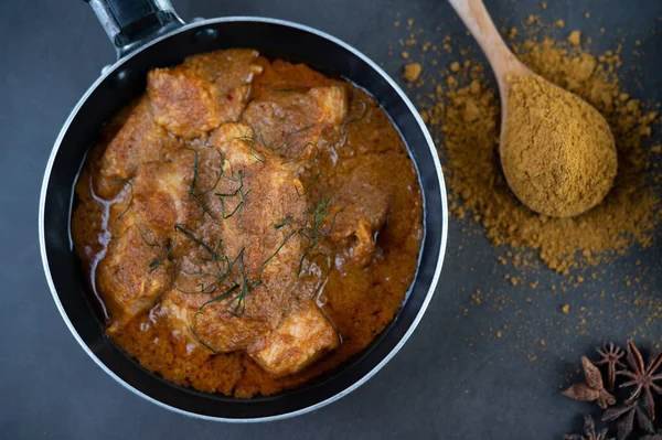 Massaman curry in a frying pan with spices on the cement floor. Selective focus