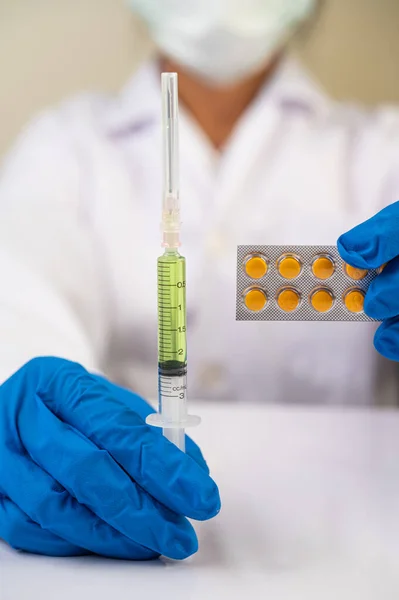 Scientists wearing masks and gloves Holding a syringe with a vaccine to prevent covic-19