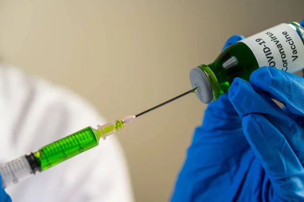 Scientists wearing masks and gloves Holding a syringe with a vaccine to prevent covid-19