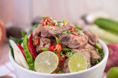 Ahşap bir masanın üzerinde beyaz bir fincanda haşlanmış domuz pirzolası. Seçici odak.