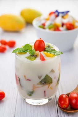 Tahtanın üzerinde cam içinde meyveli yoğurt. Seçici odak.